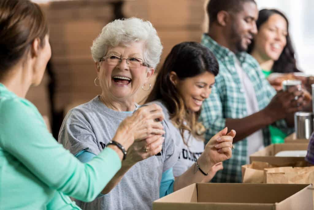 beautiful cheerful senior woman volunteers at food bank